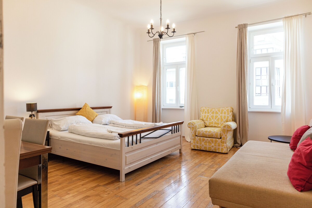 Ein Hotelzimmer mit einem Bett, einem Sessel, einer Couch und einem Schreibtisch.