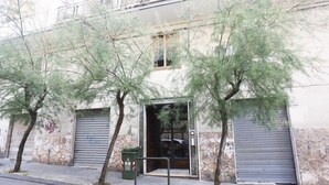A building with a stone facade, a metal door, and a green trash bin. - Bright apartment totally new both in terms of renovation and furnishings, accommodates up to 6 people and is located in a very central district: just 5 minutes walk from Corso Vittorio Emanuele, in an area fully served by shops including pharmacy, post o (Salerno)