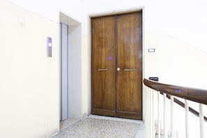 A wooden double door with a metal handle, a white wall, and a tiled floor. - Bright apartment totally new both in terms of renovation and furnishings, accommodates up to 6 people and is located in a very central district: just 5 minutes walk from Corso Vittorio Emanuele, in an area fully served by shops including pharmacy, post o (Salerno)