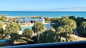 Ein Strandgrundstück mit Swimmingpool, Palmen und Meerblick.