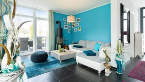 Ein modernes Wohnzimmer mit blauer Akzentwand, einer Couch, einem Couchtisch und einem Kamin.