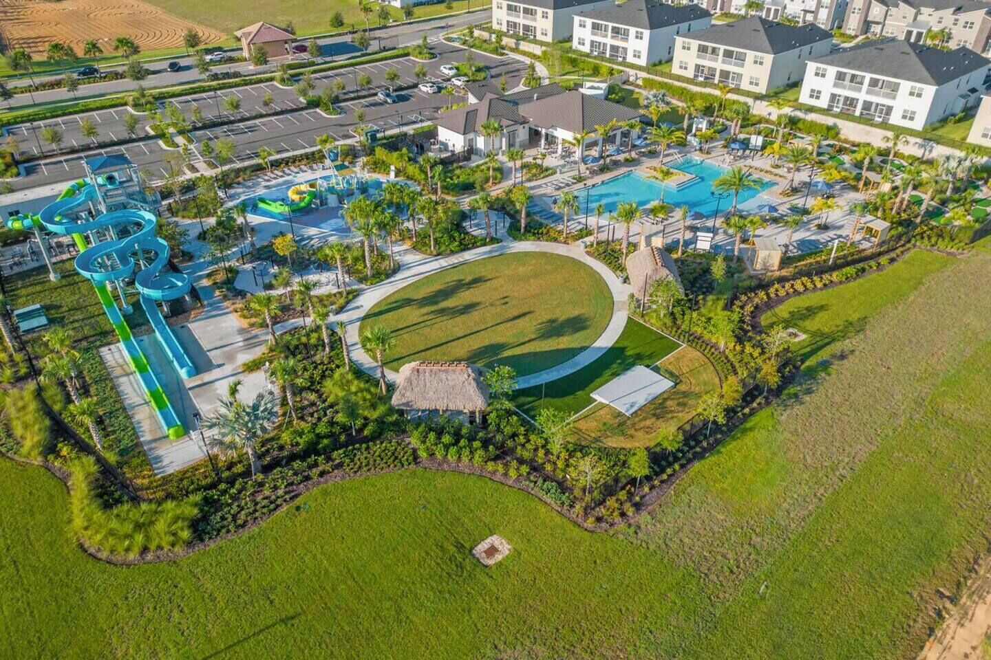 Vista aérea de un resort con una gran piscina, parque acuático y varias edificaciones.