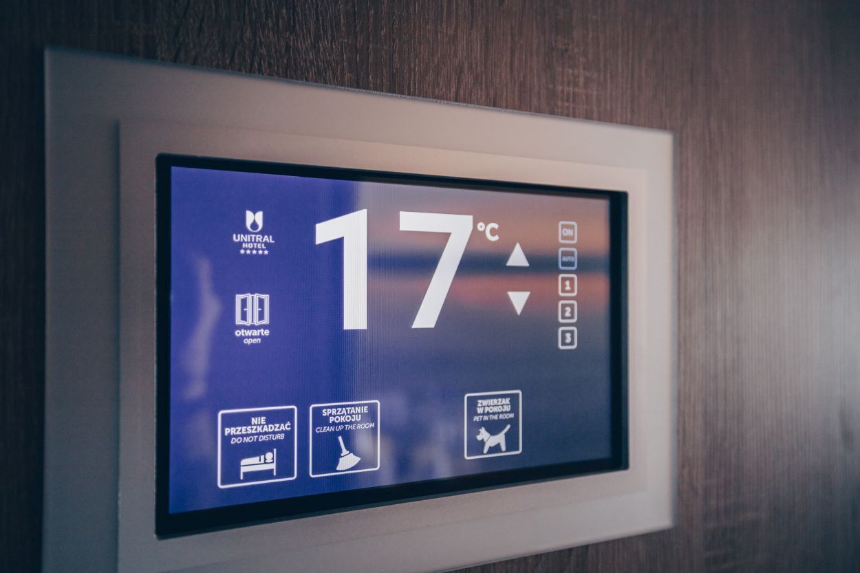 A digital display with the temperature reading of 17°C, a hotel logo, and icons for room status and cleaning instructions.