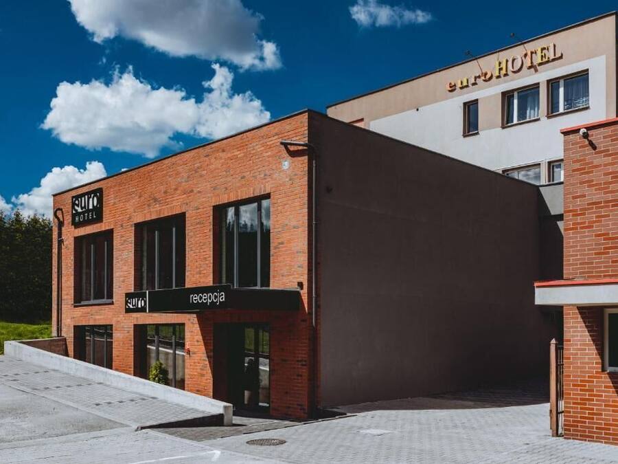 Un hotel moderno con fachada de ladrillo, zona de recepción y cielo despejado.