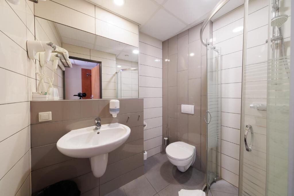 A modern bathroom with a sink, toilet, and glass-enclosed shower.