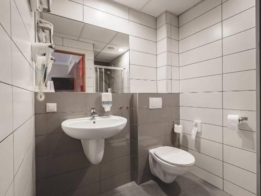 Ein modernes Badezimmer mit Waschbecken, Toilette und Spiegel.