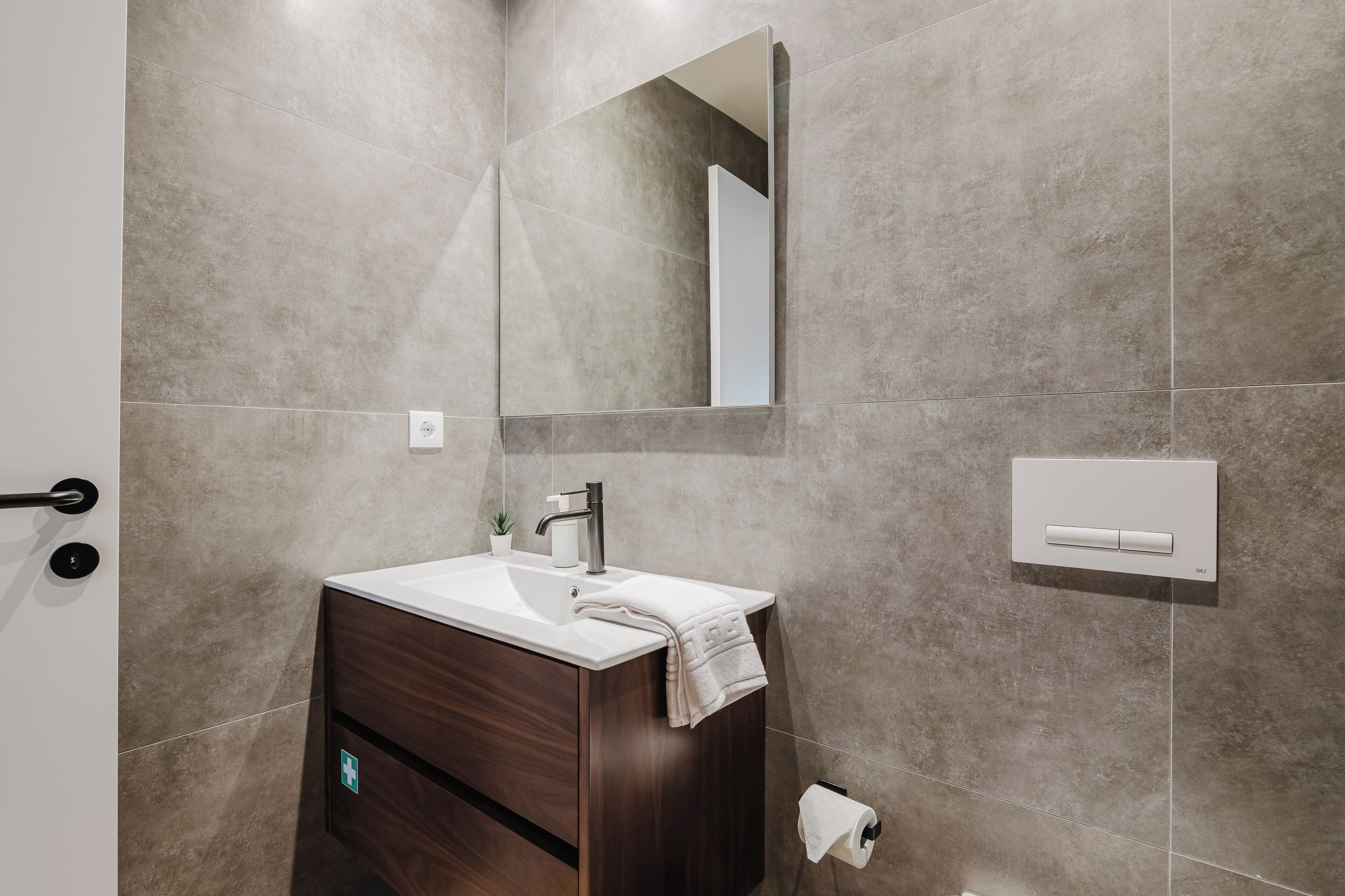 Ein modernes Badezimmer mit Waschbecken, Spiegel und Handtuchhalter.