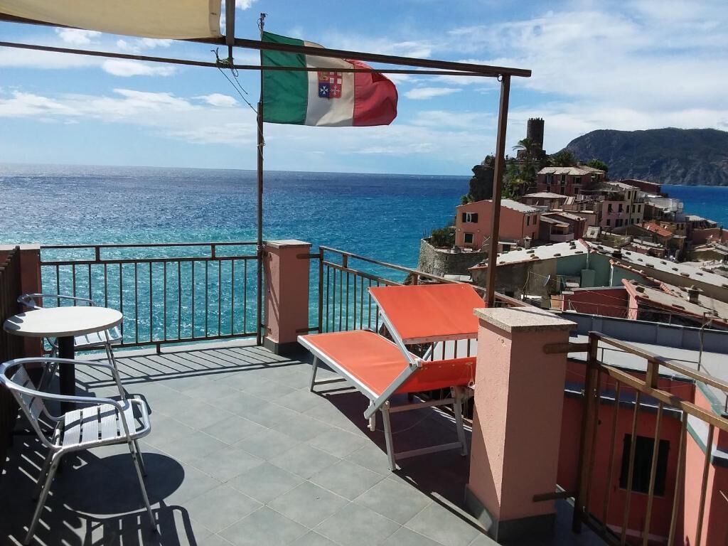 A balcony with a view of the sea and a town.