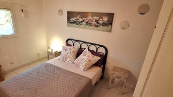 Tabla de planchar con plancha, internet y ropa de cama