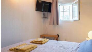 Tabla de planchar con plancha, internet y ropa de cama