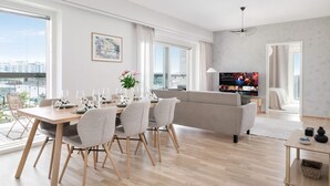 Ein modernes Wohnzimmer mit einer Couch, einem Esstisch und einem Fernseher.
