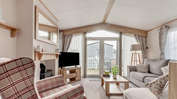 Un salon comprenant un canapé, un téléviseur, une table basse et un balcon avec vue.