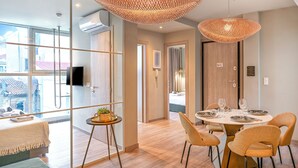 A modern hotel room with a dining area, large windows, and a view of the outside. - Karitsi Suites (Athens)
