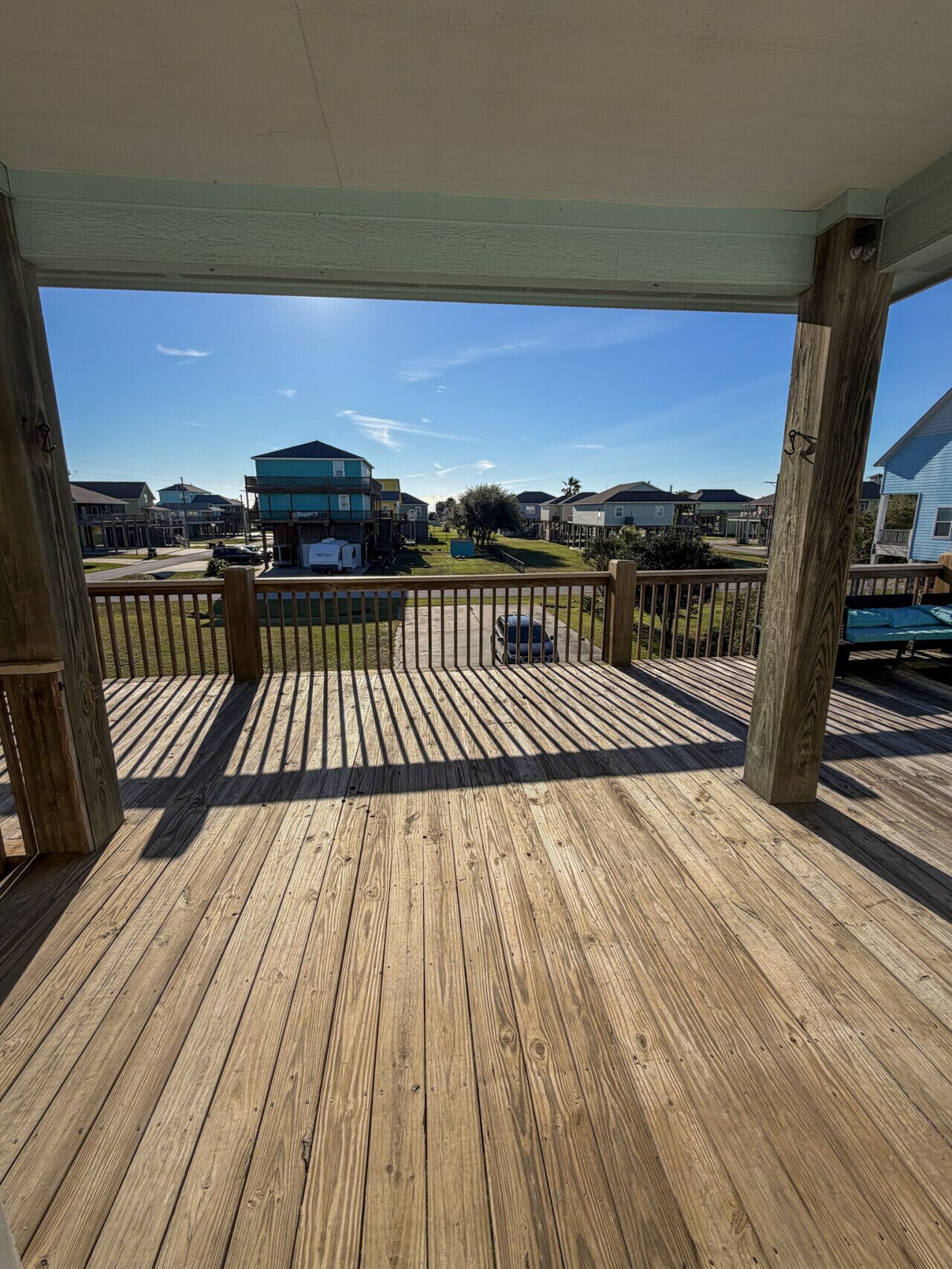 Una terraza de madera con vistas a una zona residencial.