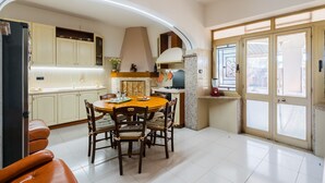 Una cocina con una mesa de comedor, sillas, armarios y una estufa.