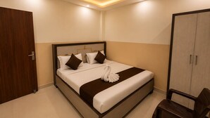 A hotel room with a bed, a wardrobe, and a ceiling fan. - Hotel Silver Palace (Kanpur)