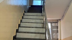 A staircase with metal railings and a view of the outside through a window. - Hotel Silver Palace (Kanpur)