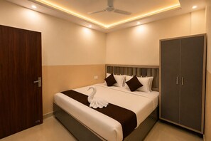 A hotel room with a bed, a wardrobe, and a ceiling fan. - Hotel Silver Palace (Kanpur)