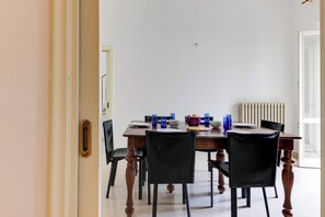 A dining area with a wooden table, black chairs, and blue glassware.