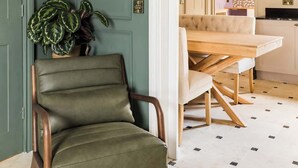 A dining area with a green wall, a framed botanical print, and a dining table with chairs. - Well Located, Cheltenham 4 Bed Townhouse & Parking (Gloucestershire)