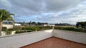 A rooftop terrace with a tiled floor, white walls, and a view of the surrounding landscape. - Holiday Home 'Dall'alba Al Tramonto' with Private Terrace, Wi-Fi and Air Conditioning (Alezio)