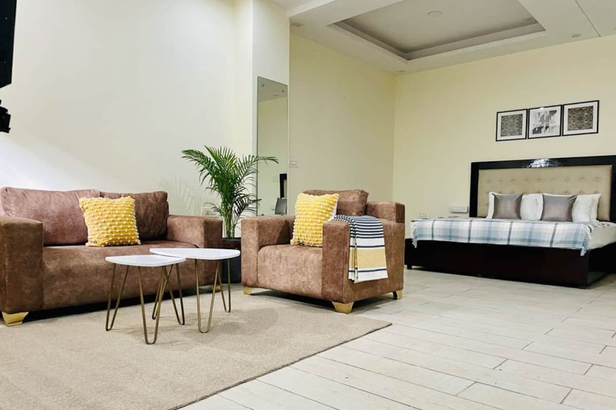 A living room with two sofas, a coffee table, and a bed with a headboard.