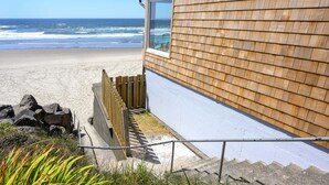 Un edificio de madera con un ventanal grande que da a una playa.
