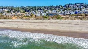 A beach with houses on a hillside. - Logans Beachfront Lodge (Lincoln City)