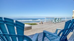 A wooden deck with blue chairs overlooking the ocean. - Logans Beachfront Lodge (Lincoln City)
