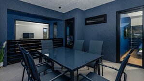 Ett modernt konferensrum med ett glasbord, svarta stolar och utsikt över en balkong med ett berg i bakgrunden.