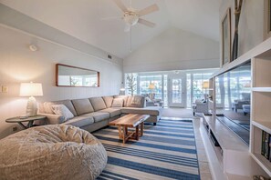 A modern living room with a sectional sofa, a wooden coffee table, and a large bean bag. - 382 Wahoo Drive (Fripp Island)