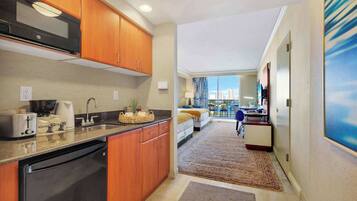 A compact kitchen with wooden cabinets, a built-in microwave, and a dishwasher.