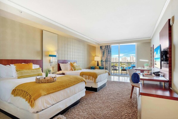 A hotel room with two beds, a desk, a chair, a TV, and a large window with a city view. - Beautiful Studio w/Private Balcony + Amazing Pool (Sunny Isles Beach)