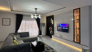A modern living room with a sofa, coffee table, and TV. - Akira's  Homes (Abuja)