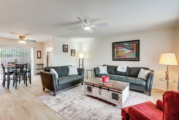 A modern living room with two sofas, a coffee table, and a dining area with a table and chairs. - Close to Golf! 55-plus Snowbird Escape in Mesa (Mesa)