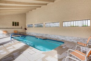 An indoor swimming pool with a tiled floor, a blue pool edge, and a few lounge chairs. - Close to Golf! 55-plus Snowbird Escape in Mesa (Mesa)