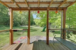 A wooden deck with a metal bench and a covered area with a 'No Smoking' sign. - Family Cabin! Close to Greenbrier River & Snowshoe (Cass)