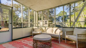 A covered outdoor seating area with wicker furniture and a patterned rug. - Dogs Welcome! Savannah Escape w/ Fenced-in Yard (Savannah)