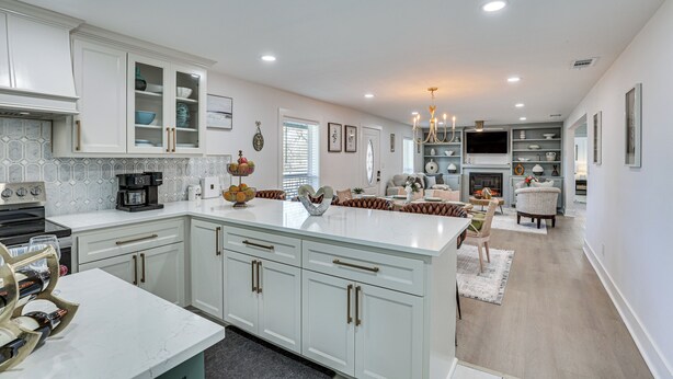 A spacious kitchen with white cabinetry, a marble countertop, and a central island. - East Texas Group Getaway! Modern Longview Home (Longview)