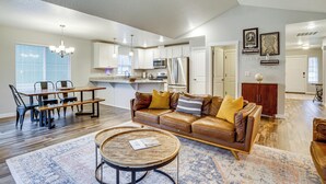Ein geräumiges Wohnzimmer mit einem braunen Ledersofa, einem Holztisch und einem Essbereich mit Holztisch und Stühlen.