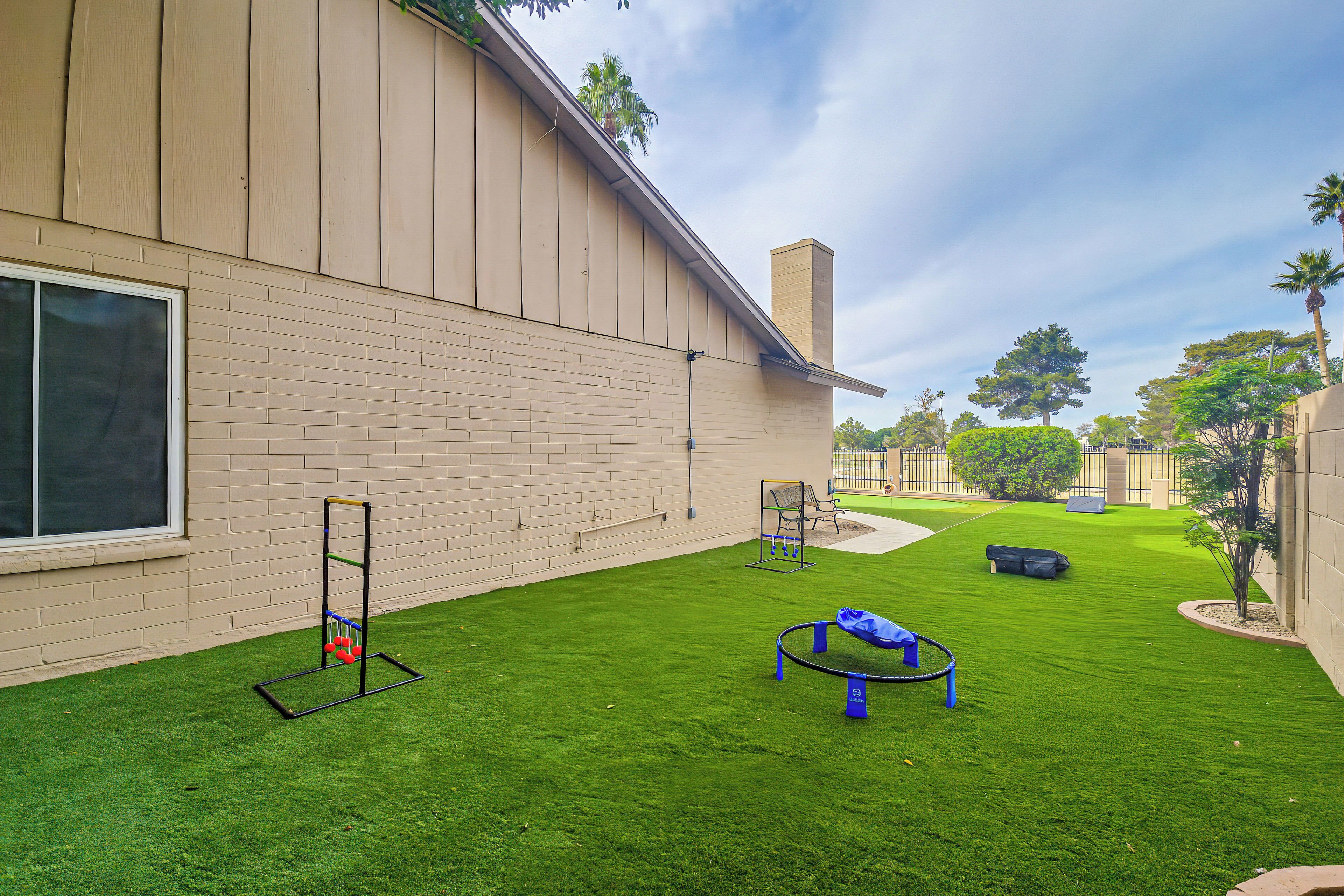A well-maintained outdoor area with artificial grass, a swing set, and a climbing frame.