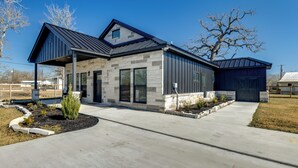 A modern two-story house with a stone facade, a covered porch, and a garage. - Lake Somerville Family Retreat: 'the Lazy Joey'! (Somerville)