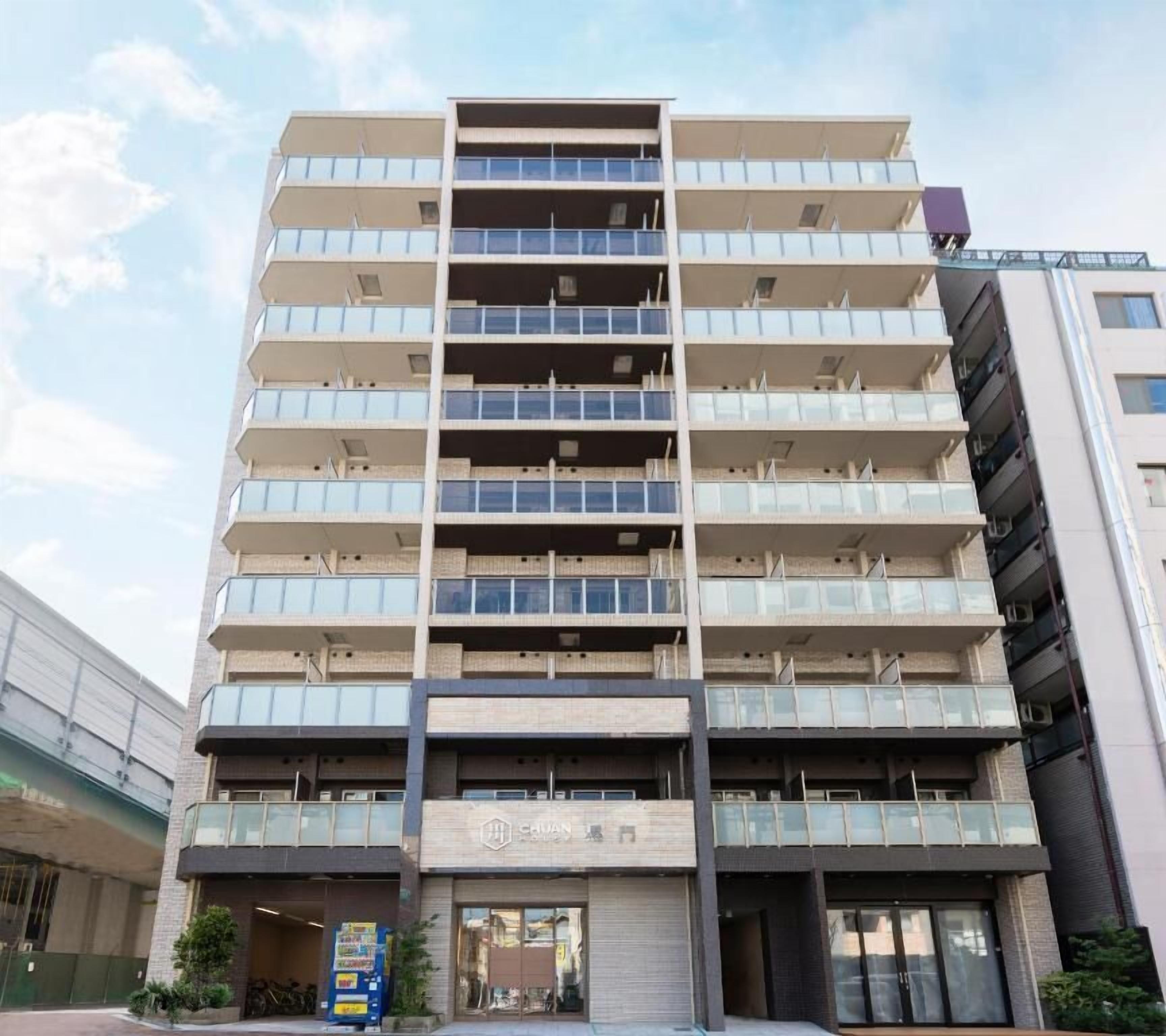 A multi-story building with a modern architectural design, featuring a series of balconies and large windows.