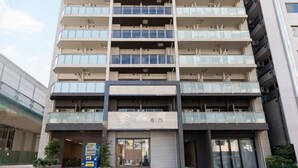 A multi-story building with a modern architectural design, featuring a series of balconies and large windows. - Chuan House Kuromon (Osaka)