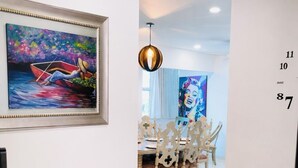 Un pasillo con comedor, un cuadro en la pared y una secuencia numérica en la pared.