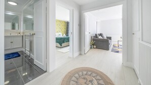 A spacious living area with a sofa and a coffee table, a separate bedroom with a bed and a bathroom with a large mirror. - Stunning Flat in Chelsea Kings Road With Balcony (London)