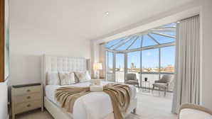 Ein geräumiges Hotelzimmer mit einem großen Bett, einer Sitzecke mit Blick und einem Balkon.