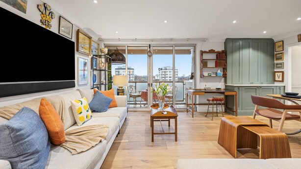 A spacious living area with a sofa, coffee table, and dining table. - Stunning Flat in Chelsea Kings Road With Balcony (London)