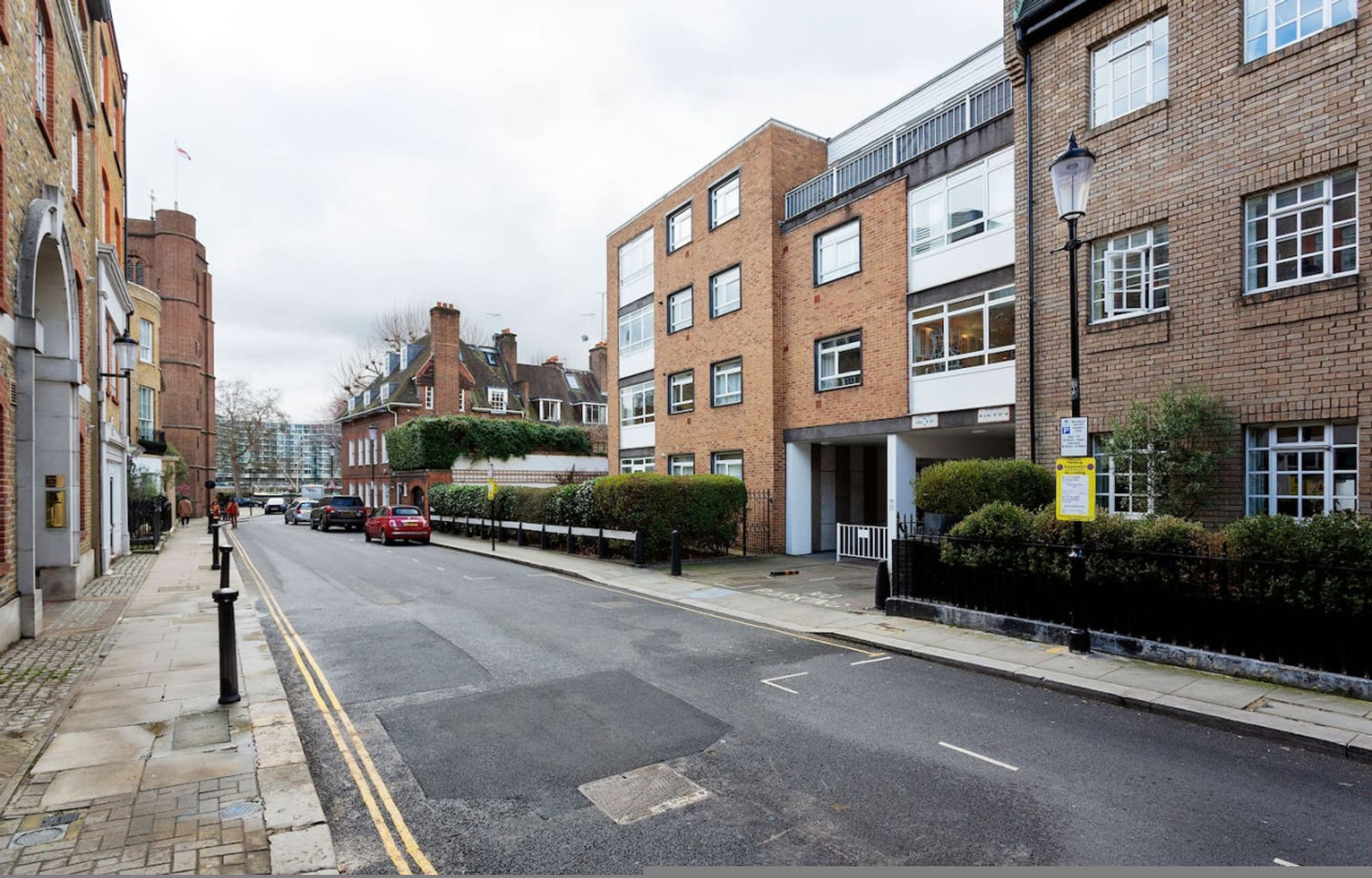 A street with residential buildings, a clear road, and a pedestrian crossing.