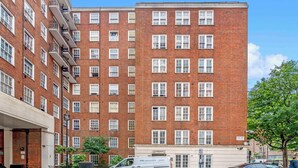 A multi-story brick building with a white facade and multiple windows. - 1 Bed Flat in London (London)